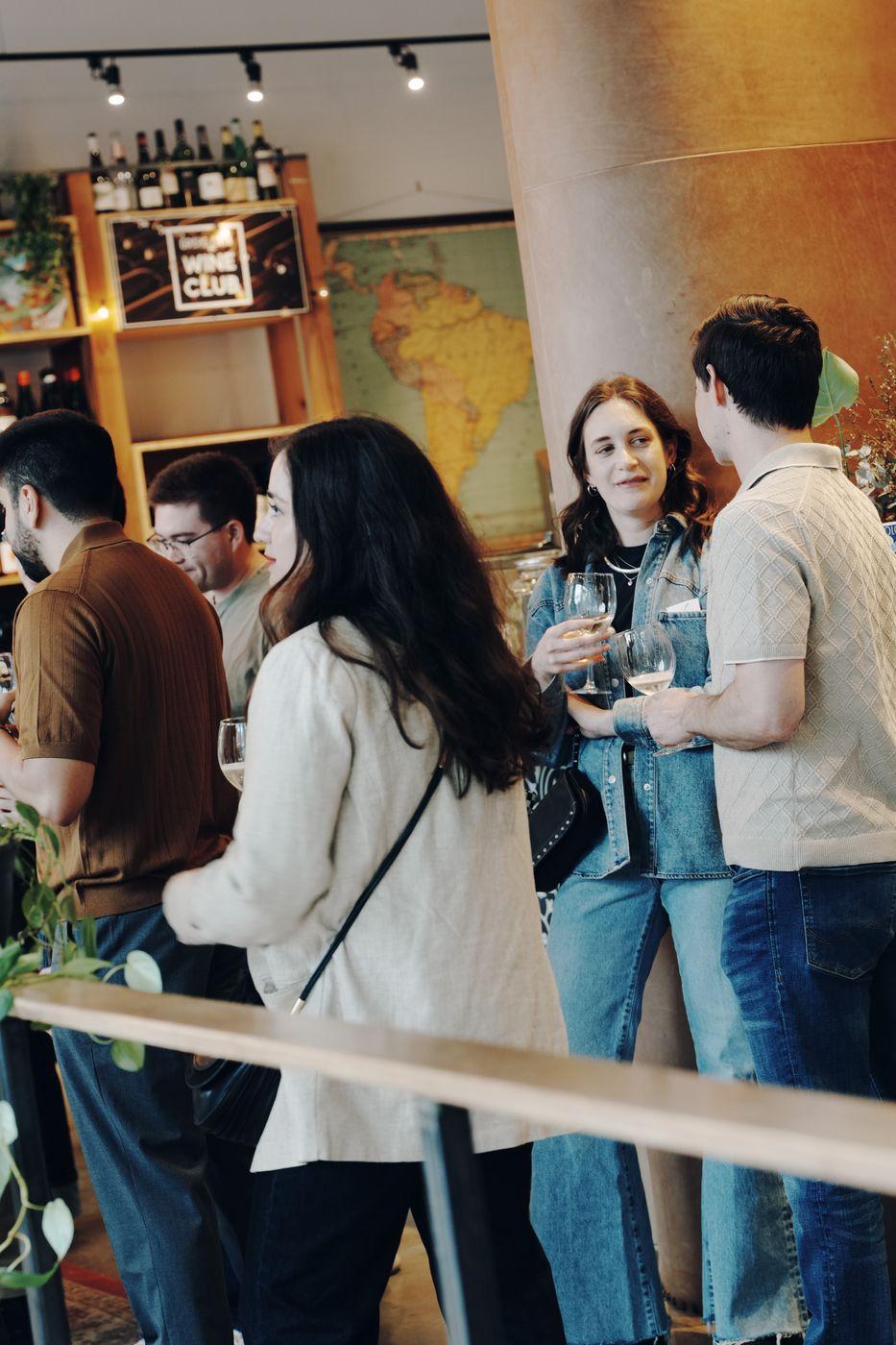 A group mingling at a Peared wine shop event