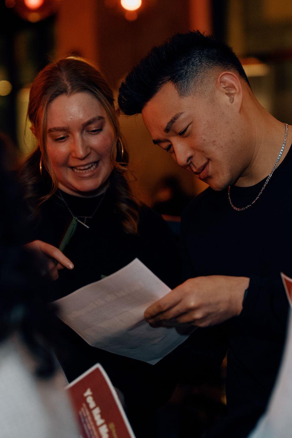 Two guests laughing over an icebreaker game card
