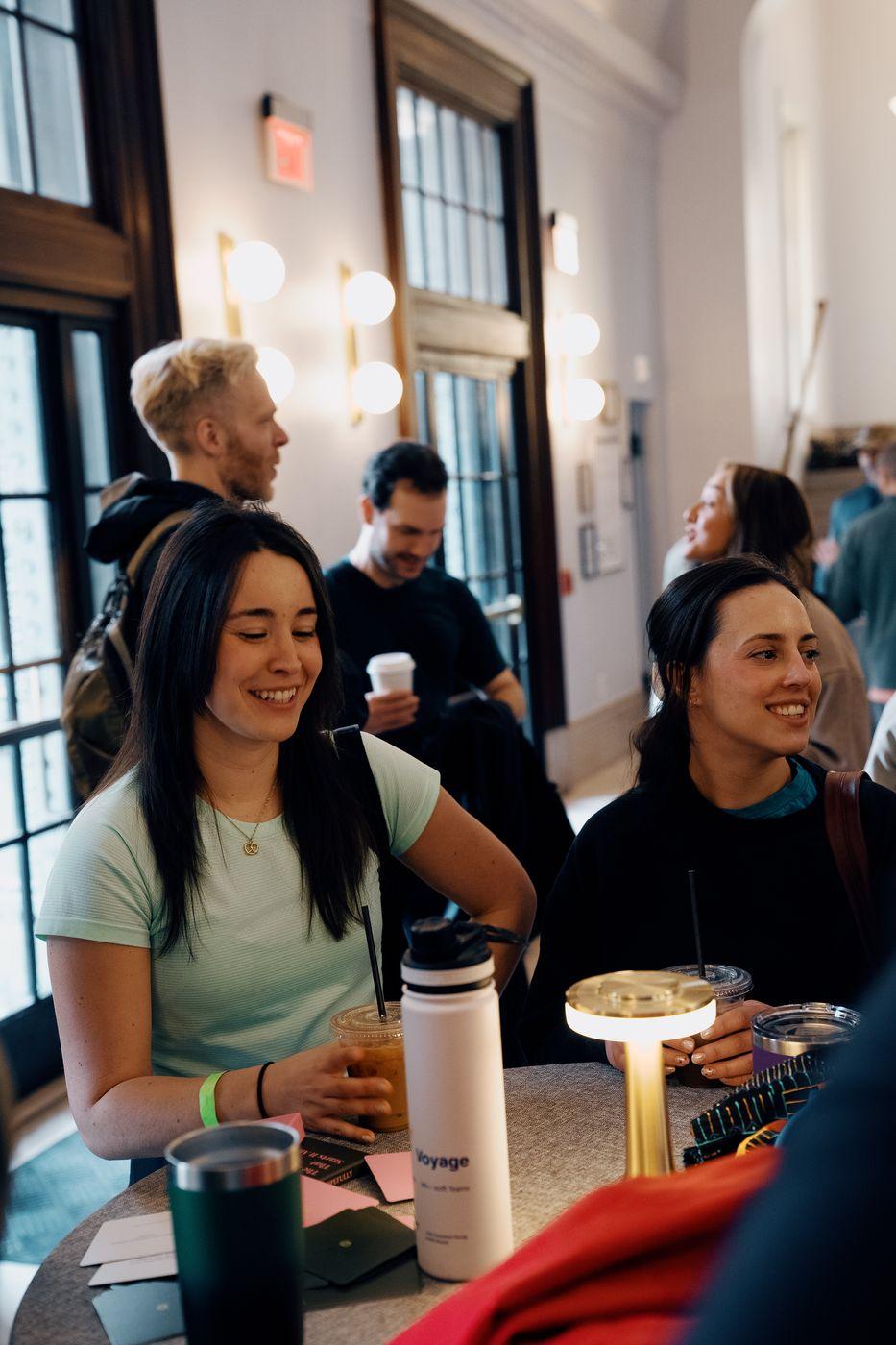 Friends laughing around a table at a Peared event